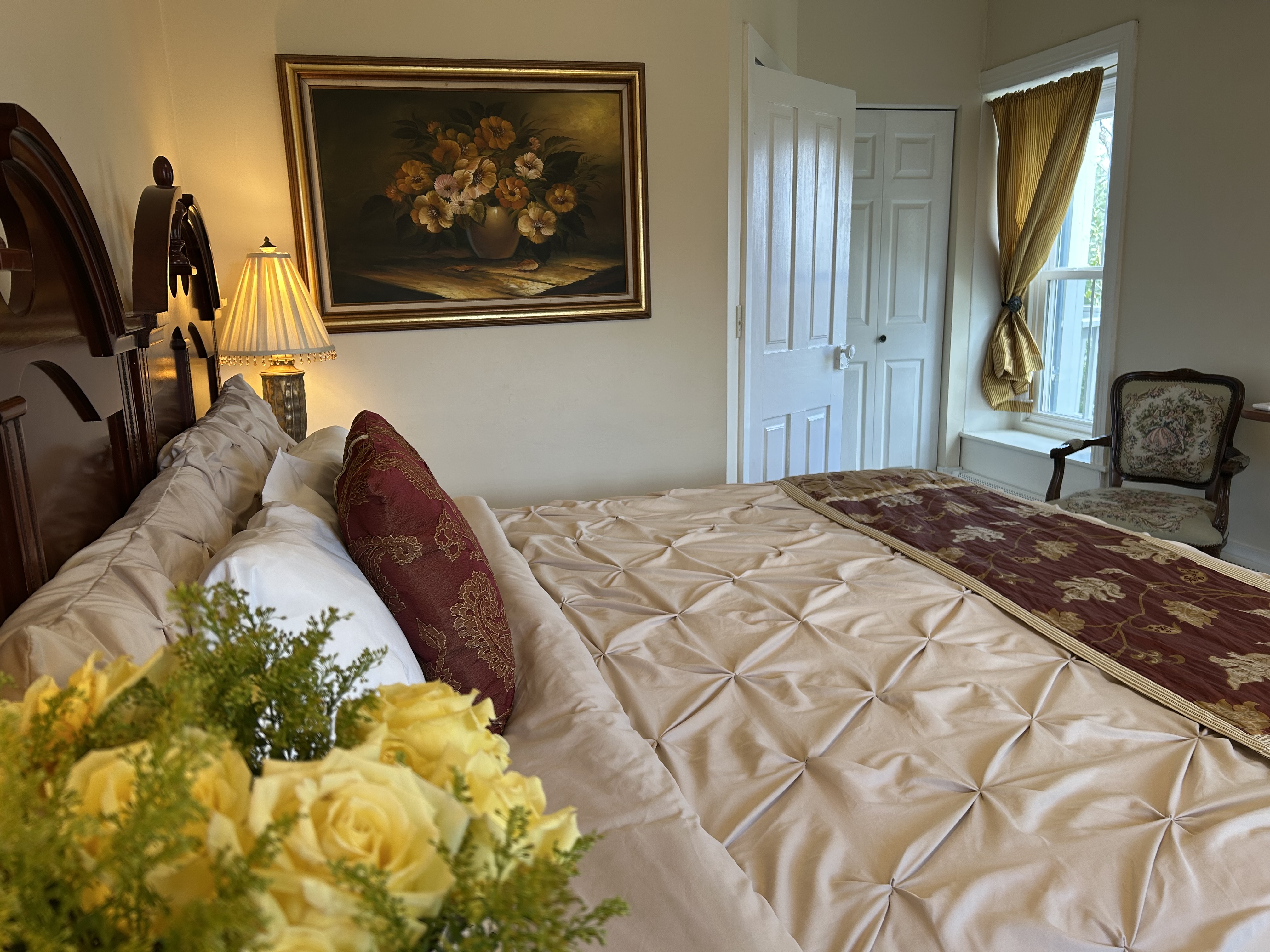 Side view of king size bed with window & chair