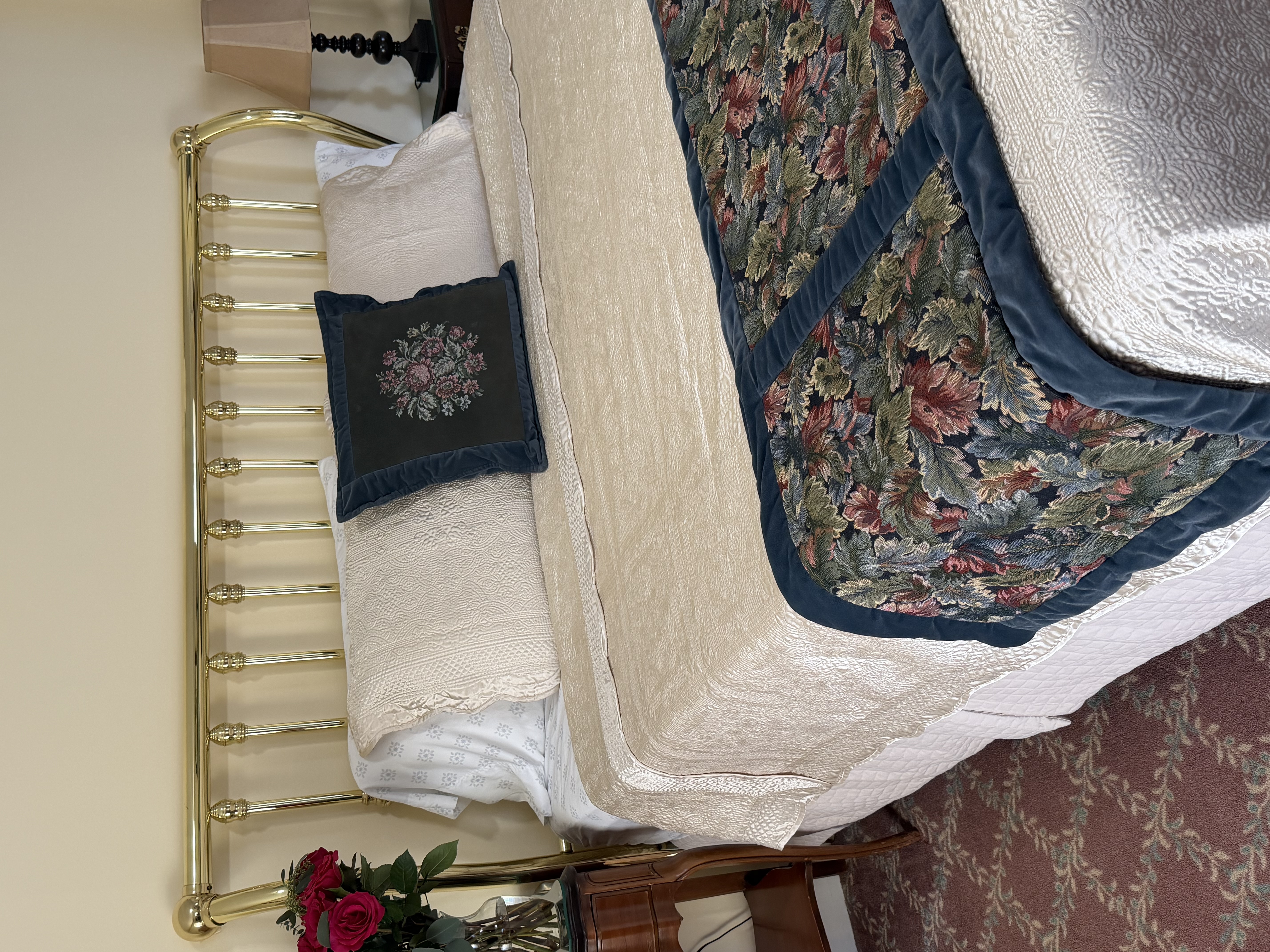 View from side of king bed, night stands with flowers