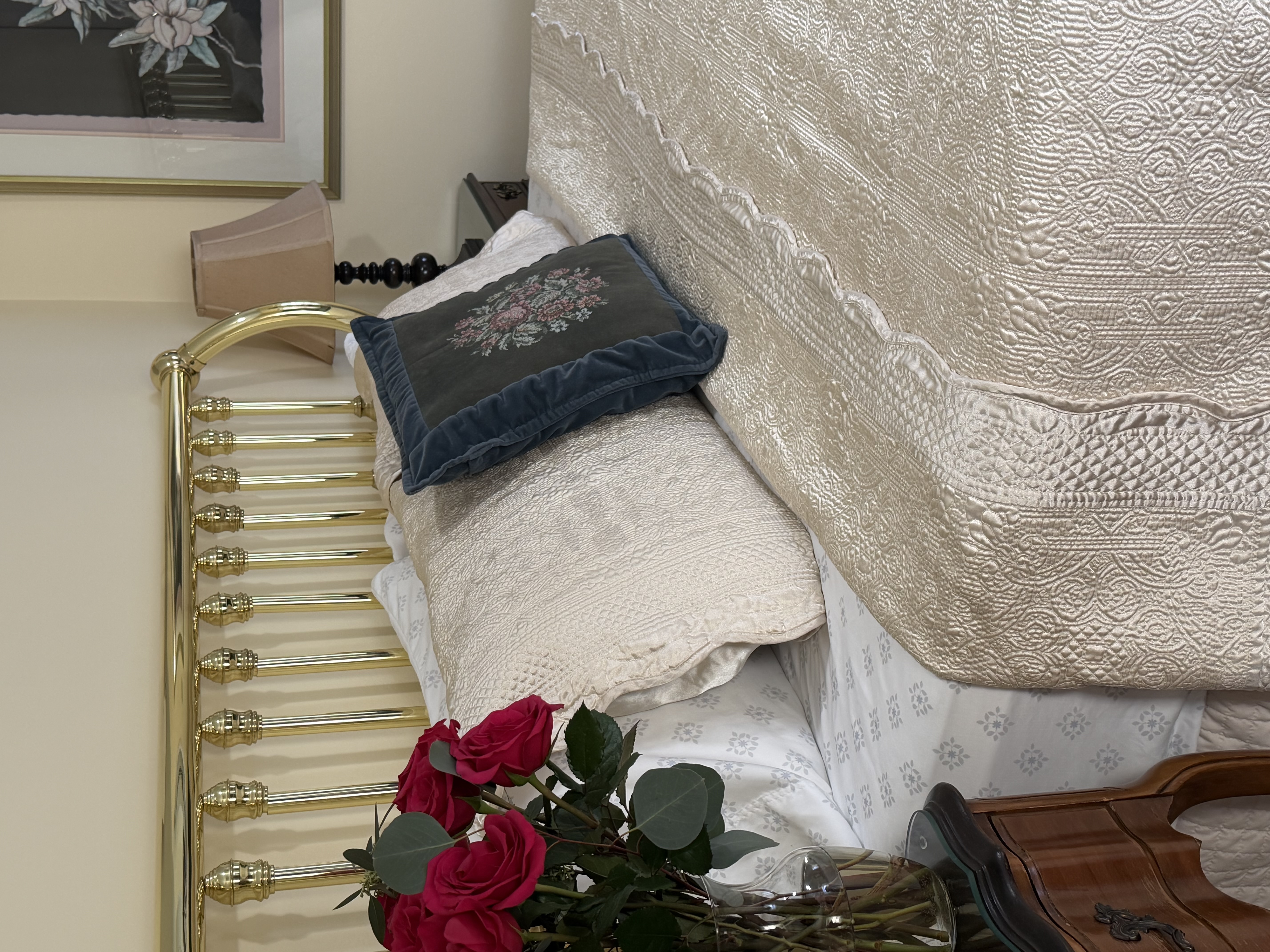 View from side of king bed, night stands with flowers