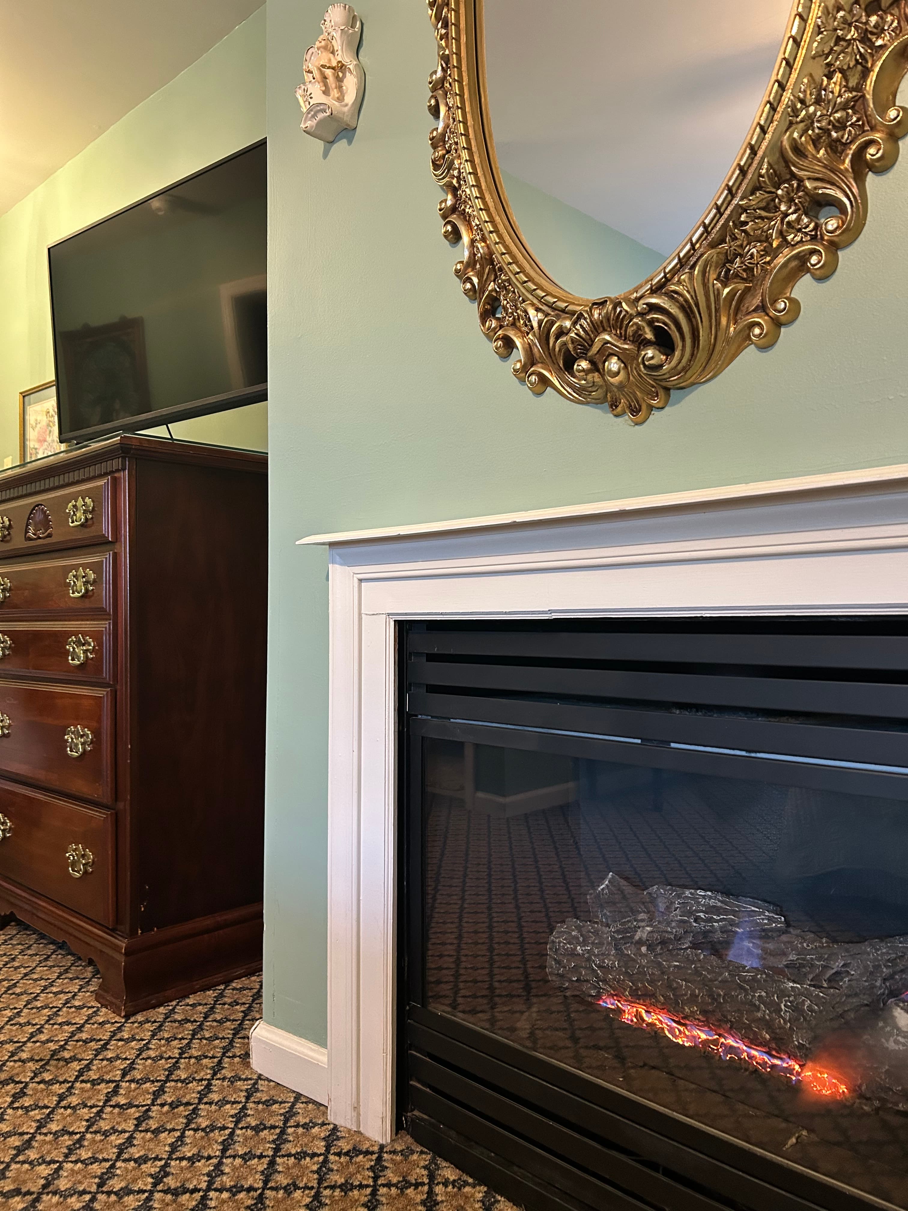 Gas fireplace with dresser and TV on top of dresser