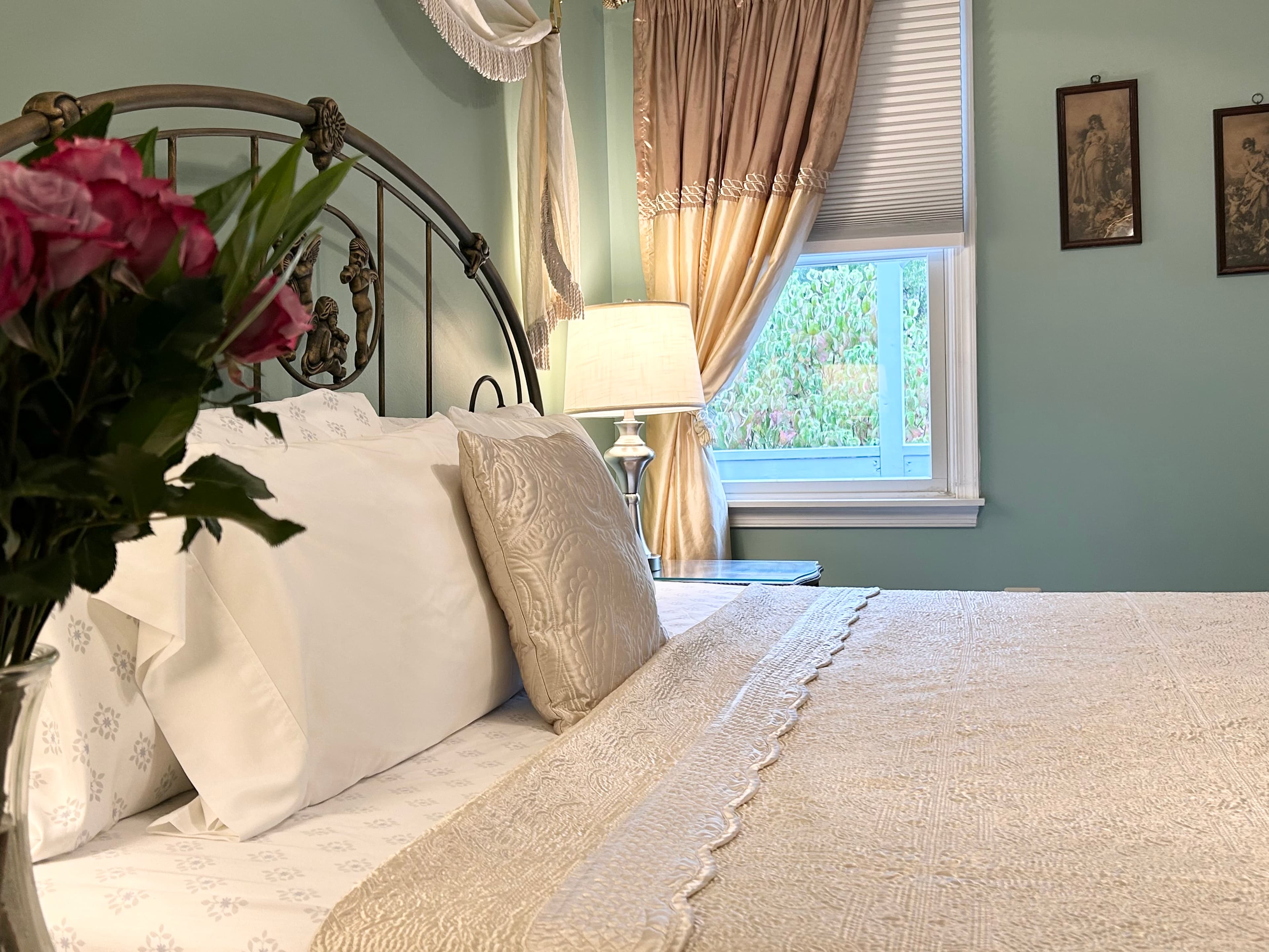 Close up of flowers on side table with king bed