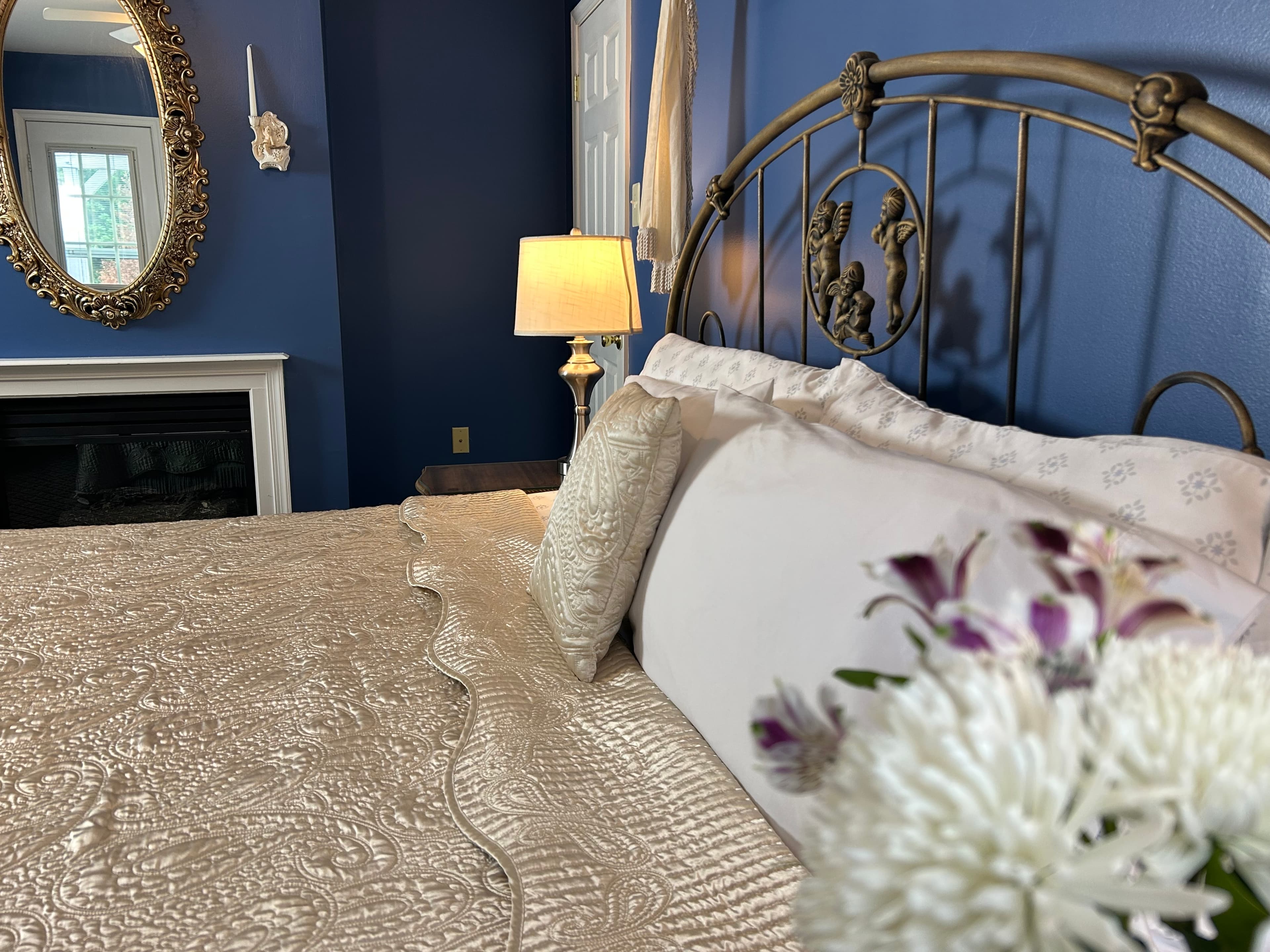 Close up of flowers, king size bed and fireplace