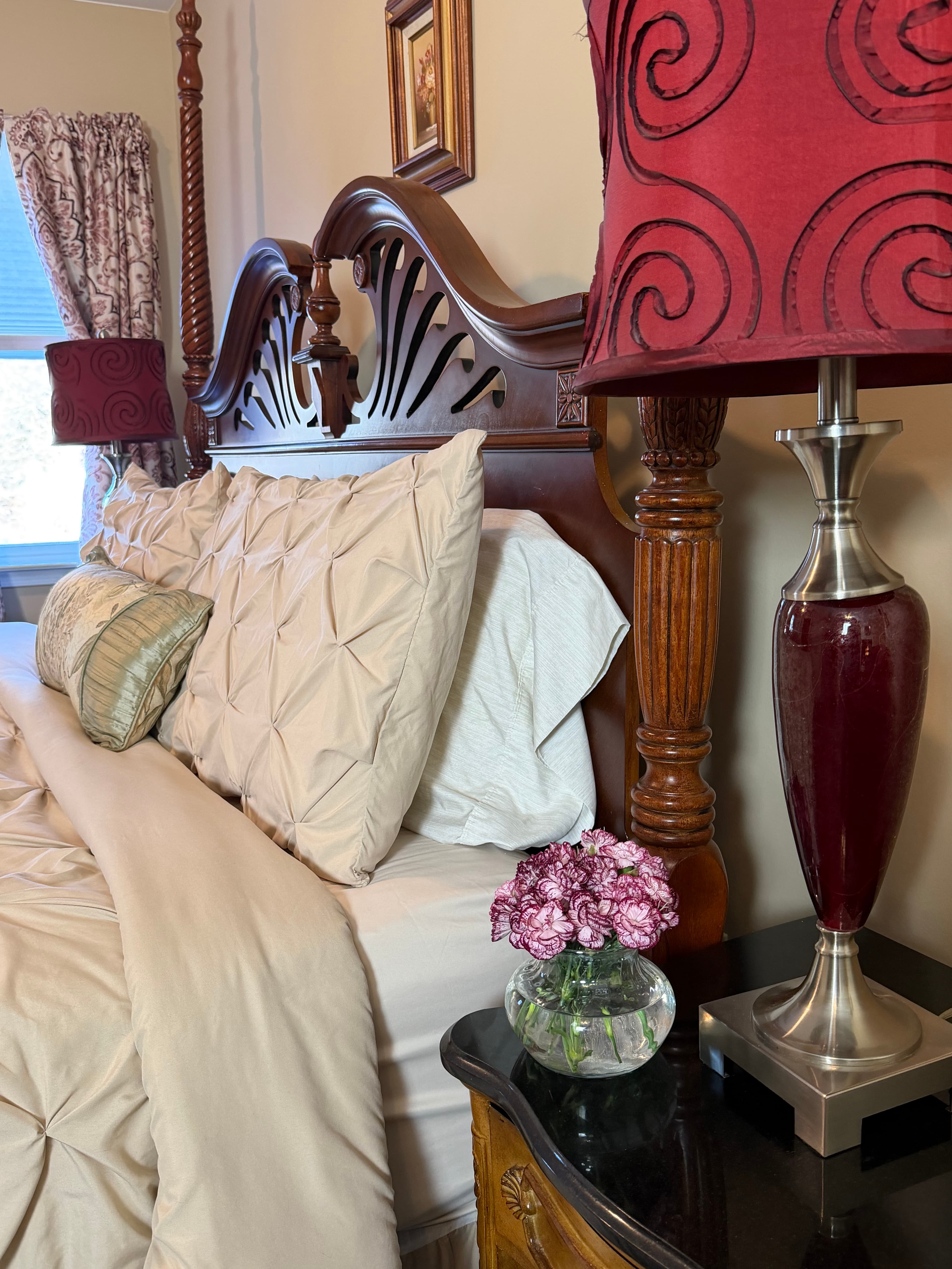 Side view of king bed & end table with flowers