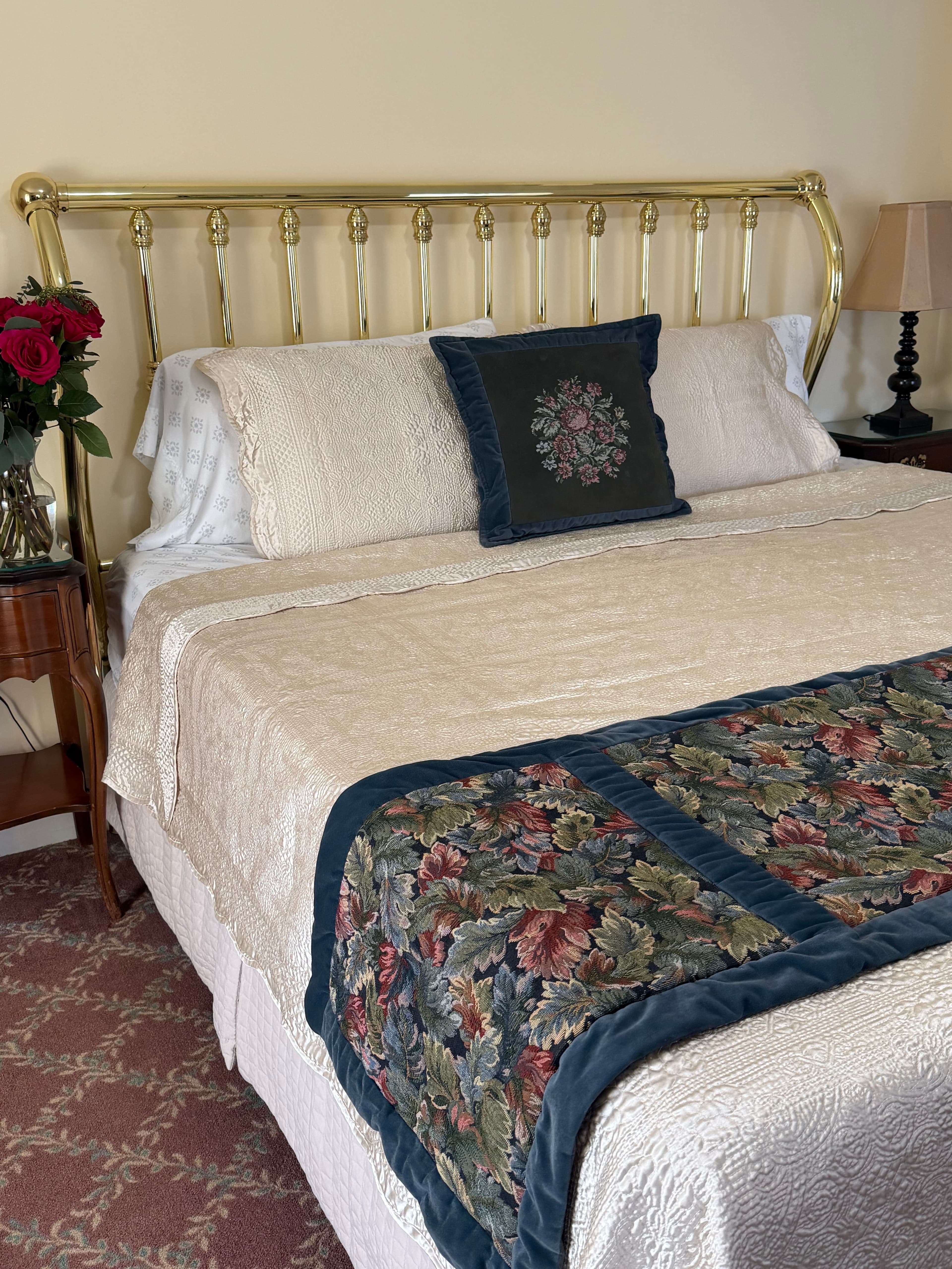 View from side of king bed, night stands with flowers