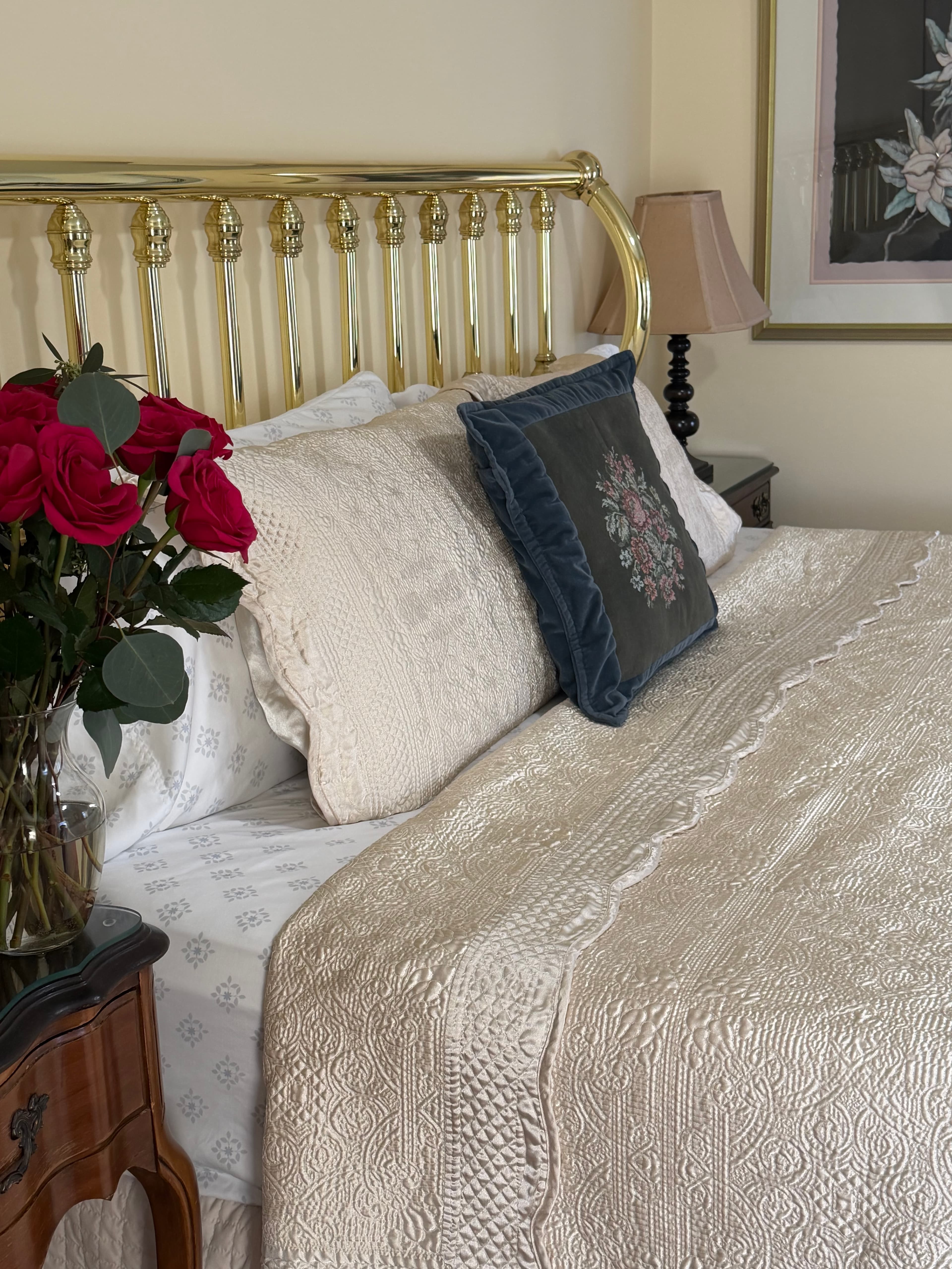 View from side of king bed, night stands with flowers