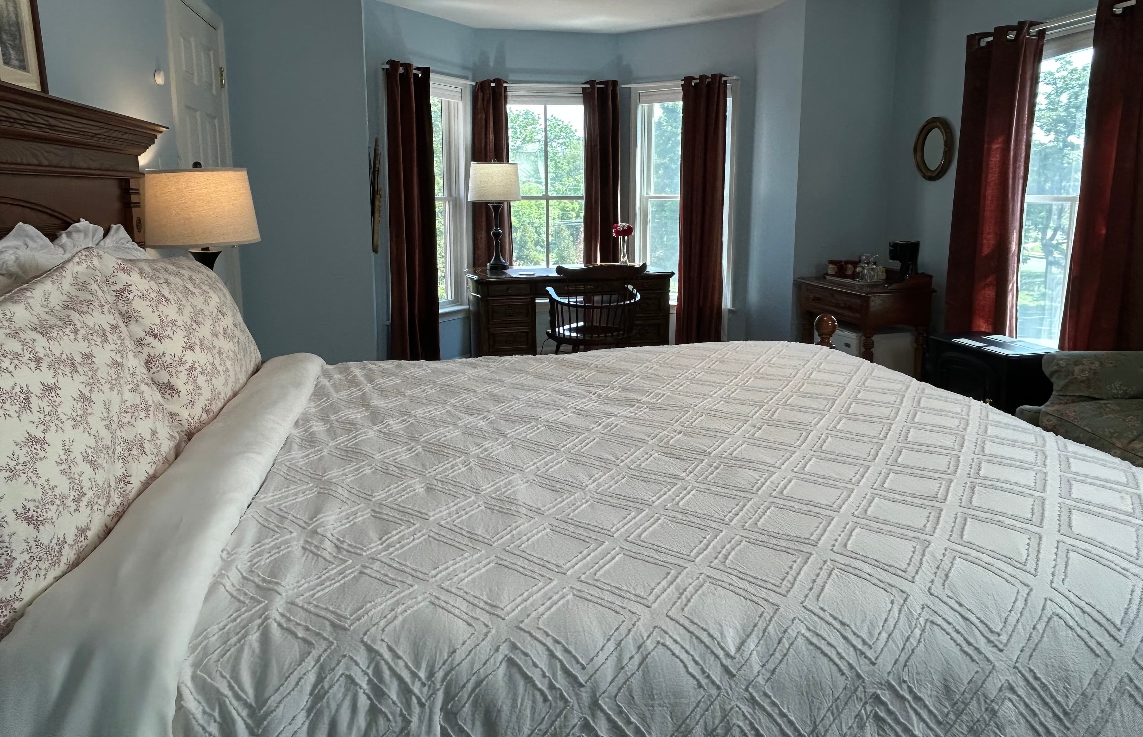 View of room over the queen bed to desk in bay windows