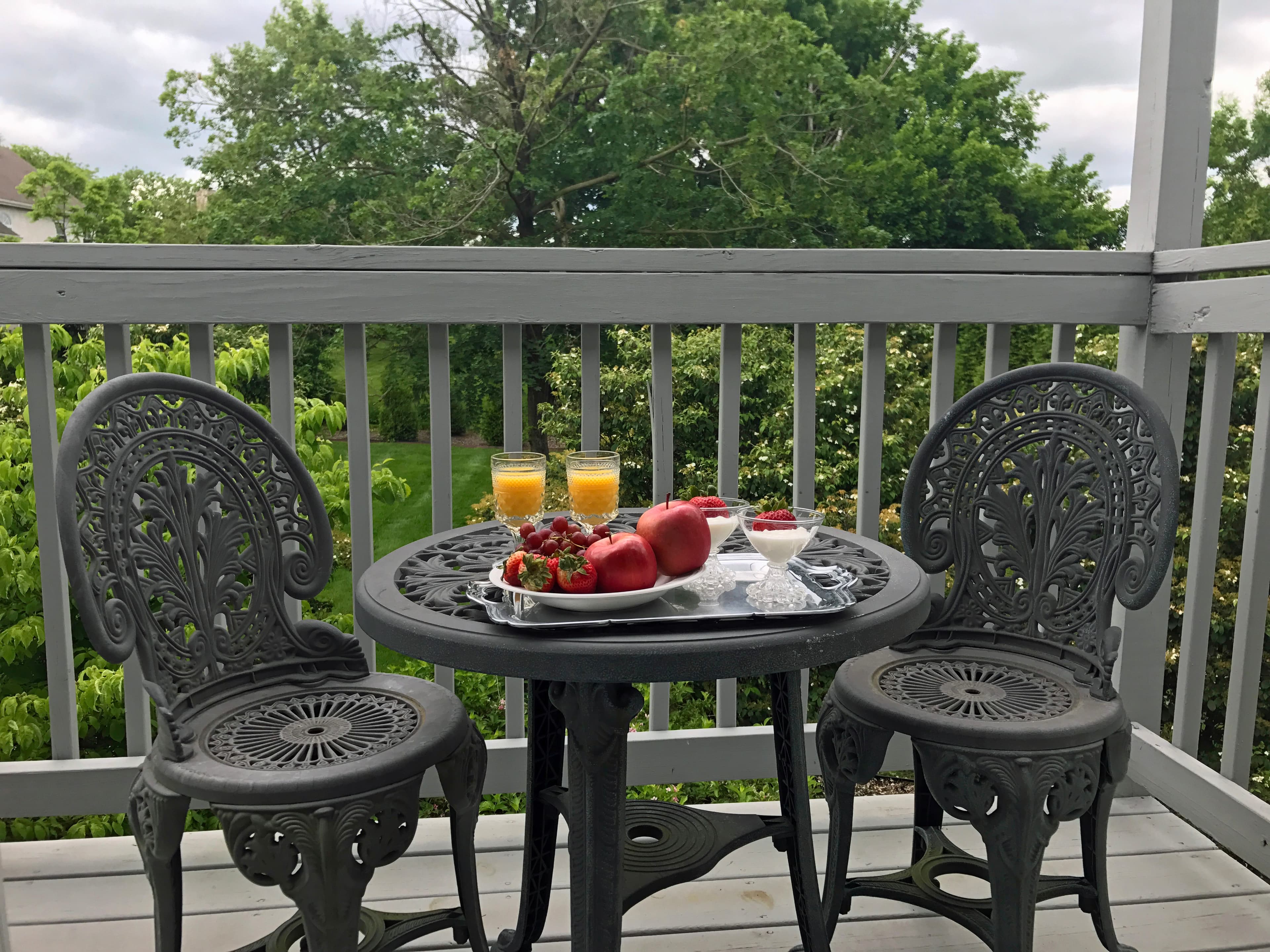 "Table and chairs on balcony set up for breakfast"