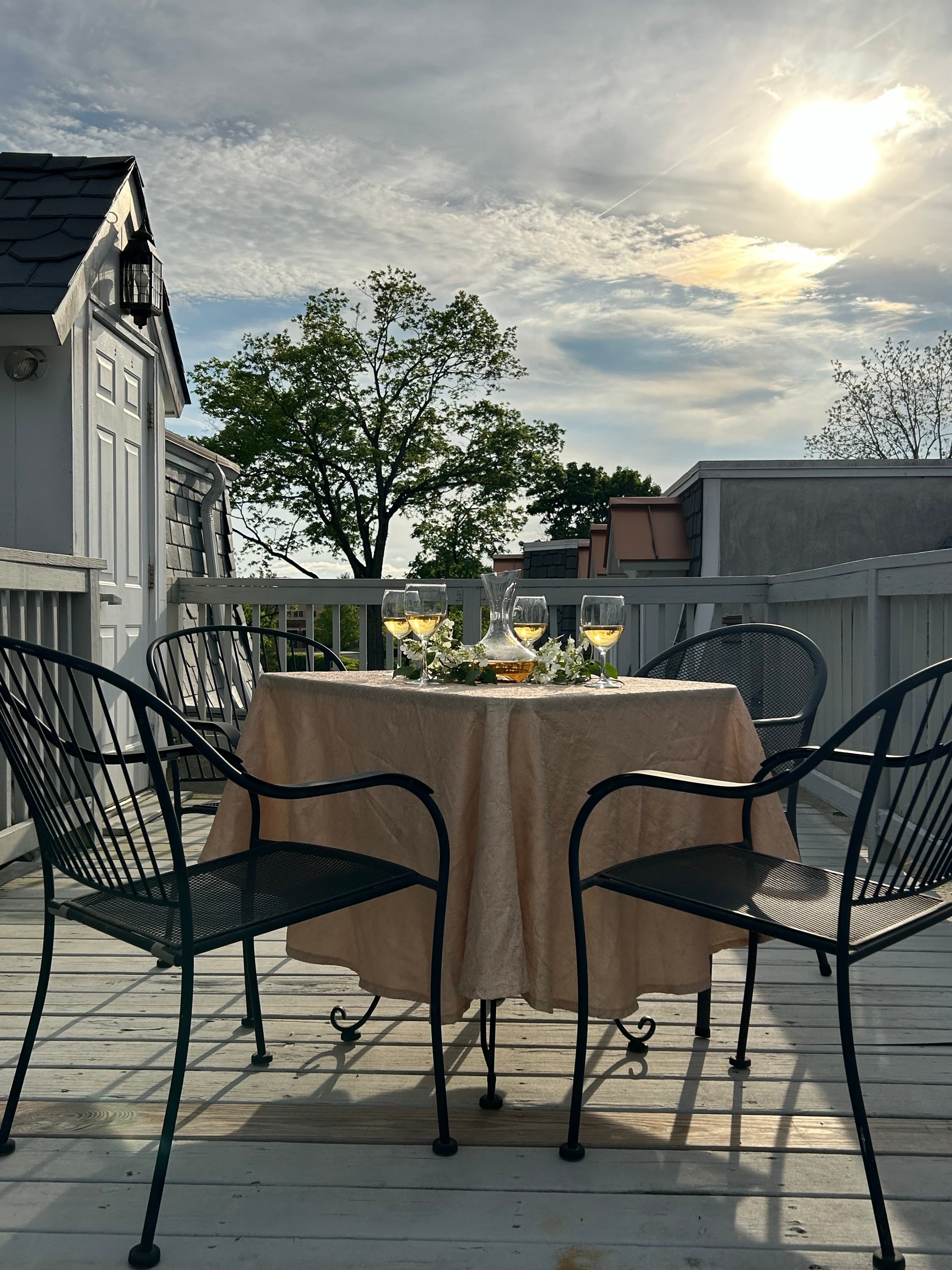 View of rooftop deck at sunset with white wine
