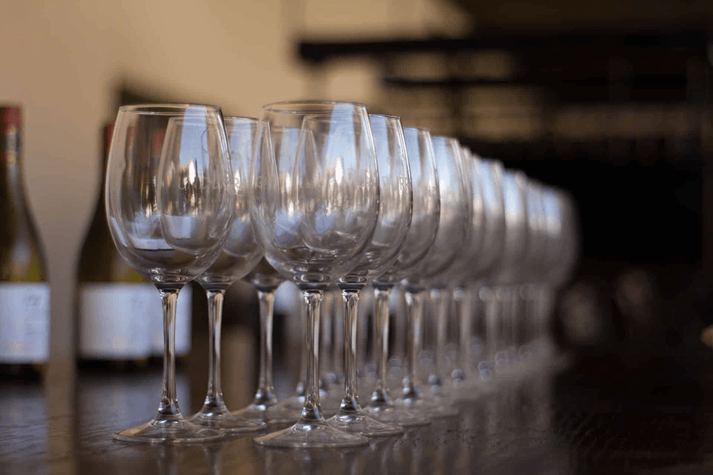 A row of elegant wine glasses lined up on a wooden table.
