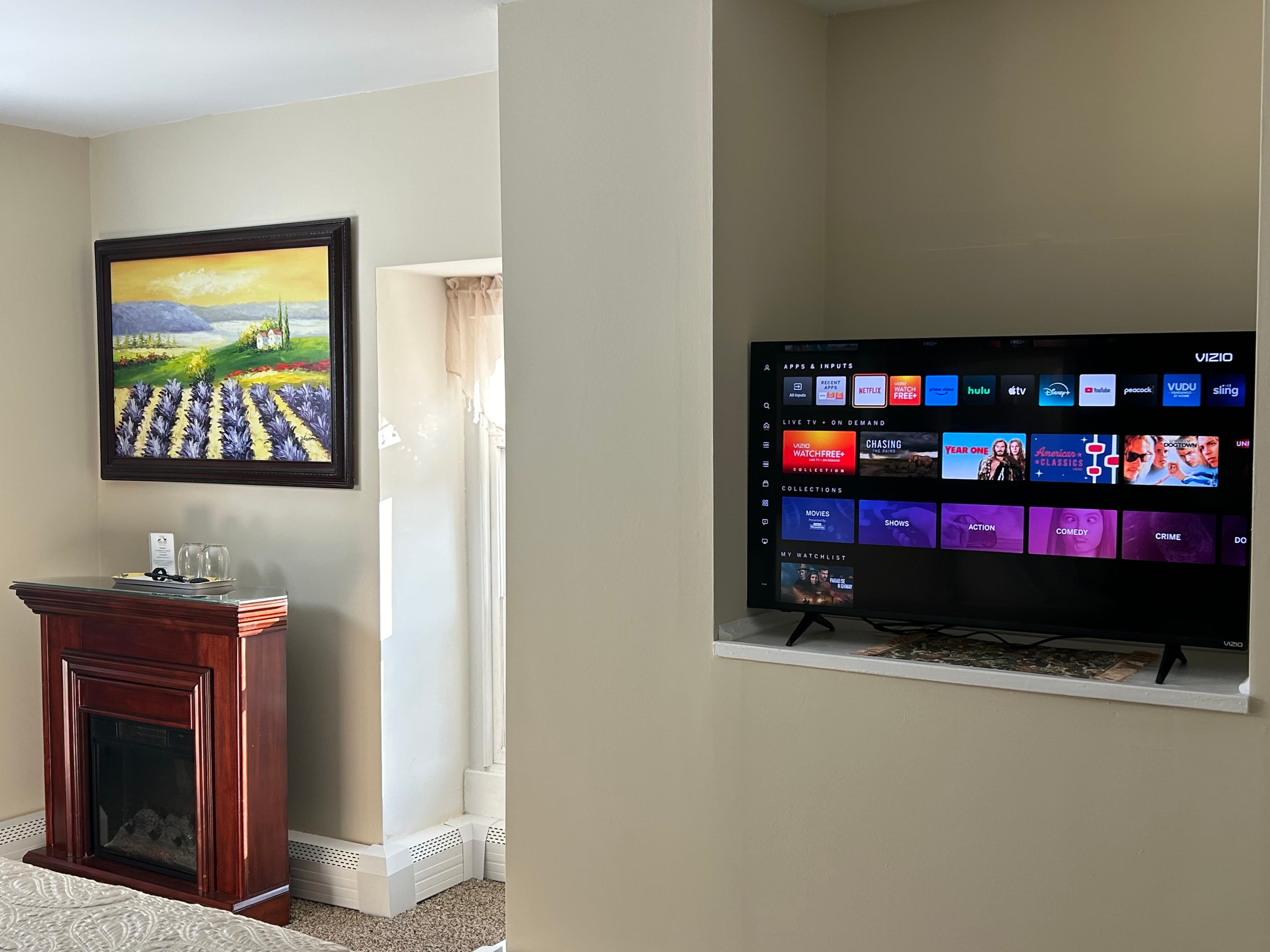 TV showing Netflix avalable and a nice painting of a lavender field above a fireplace