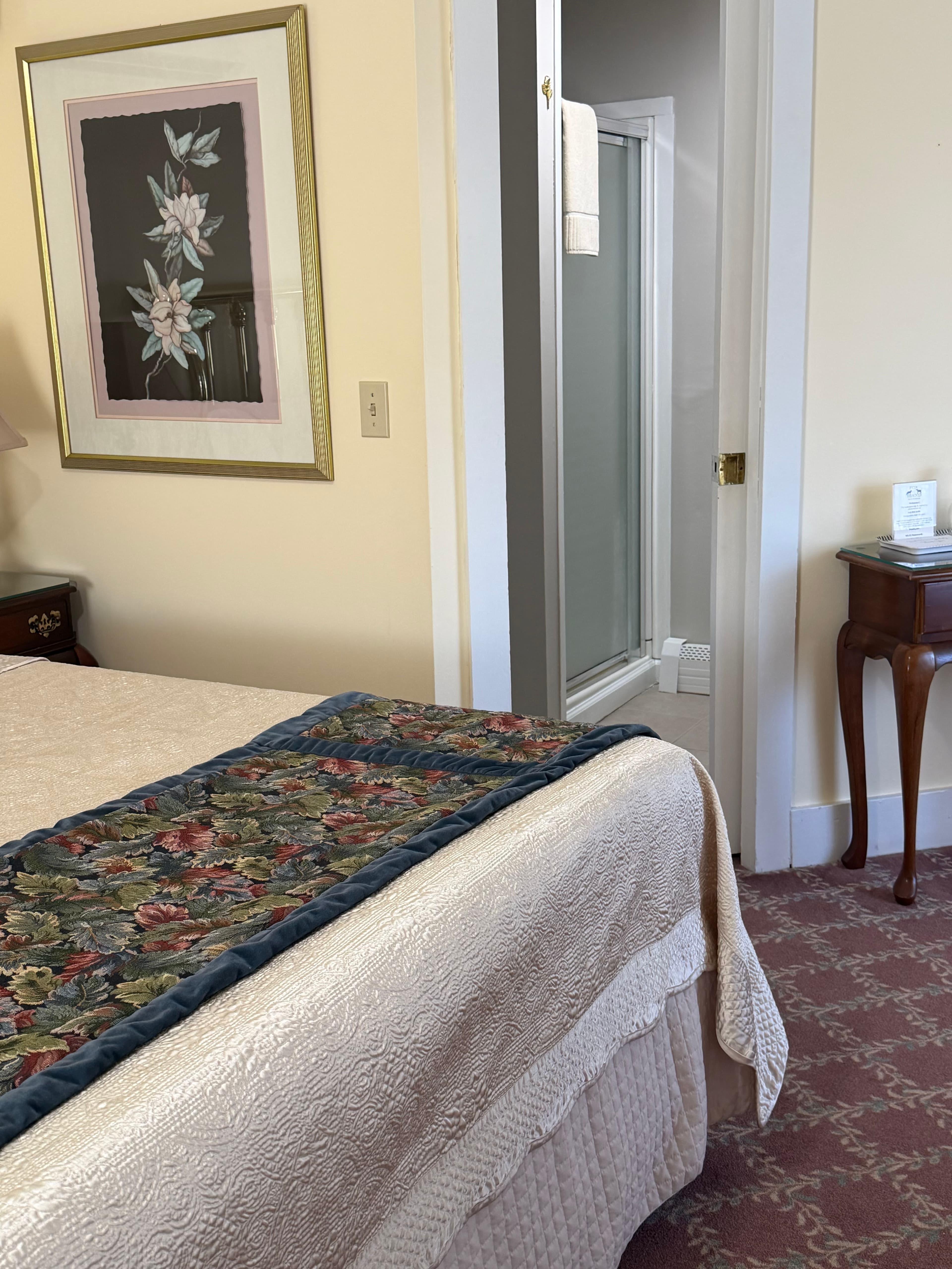 View at the end of the bed with the entrance to the bathroom