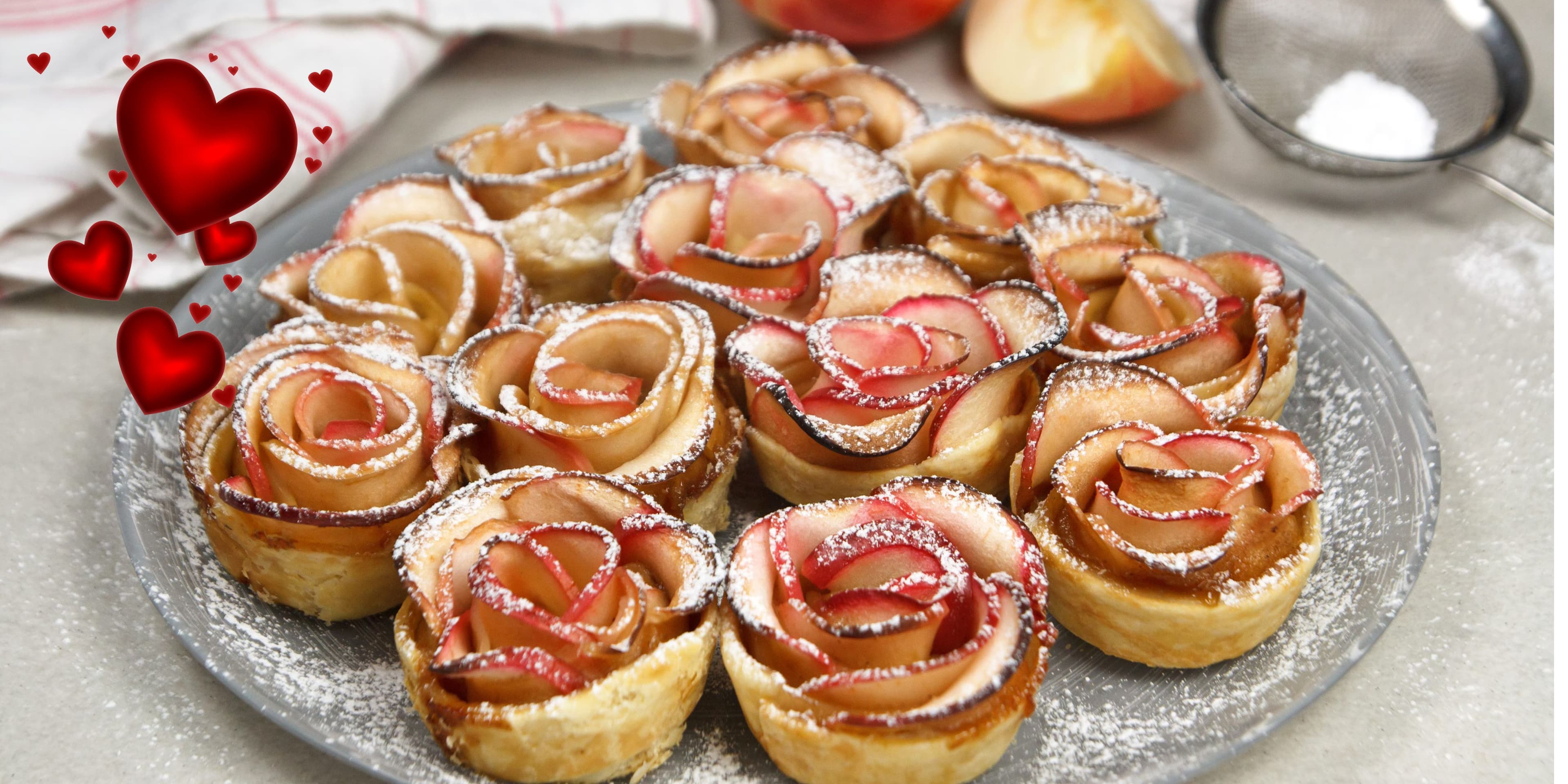 A platter of apple rose pastries dusted with powdered sugar.
