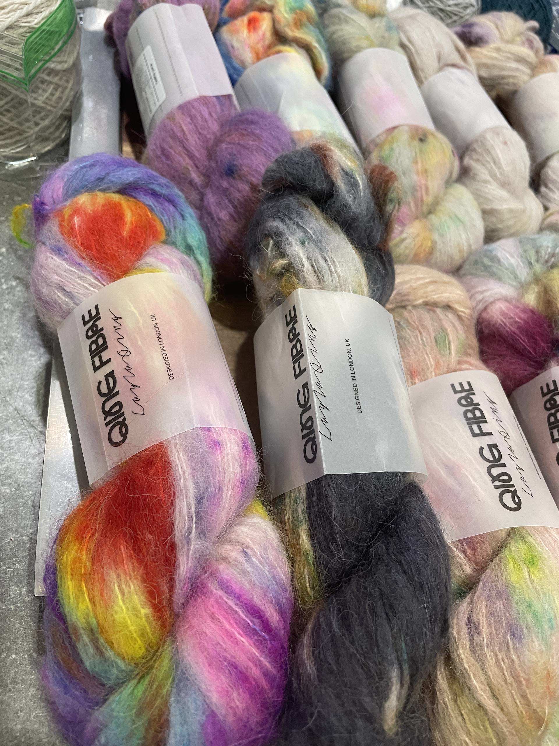 Colorful skeins of yarn are neatly arranged, showcasing a variety of textures and hues.
