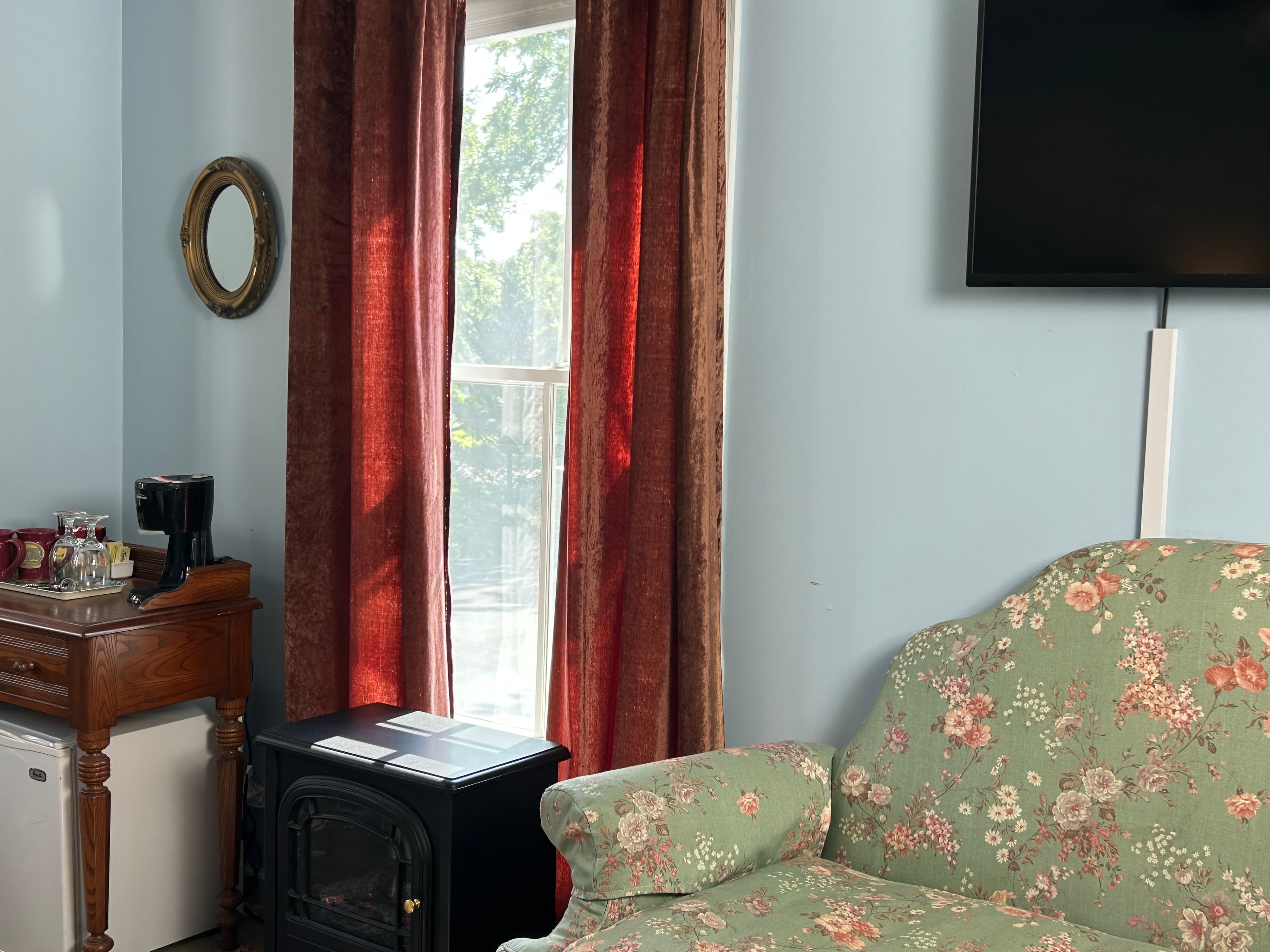View of sitting area, window, TV, table with amenities & mini fridge